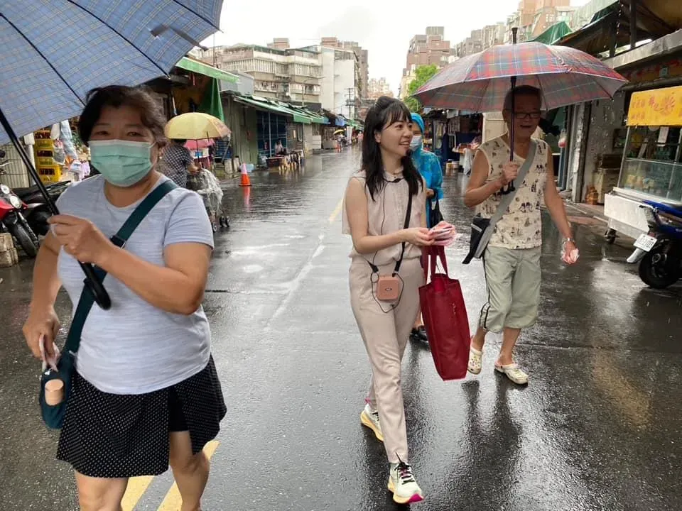 民進黨立委高嘉瑜(中)在滂沱大雨中掃街拜票。(圖取自高嘉瑜臉書)