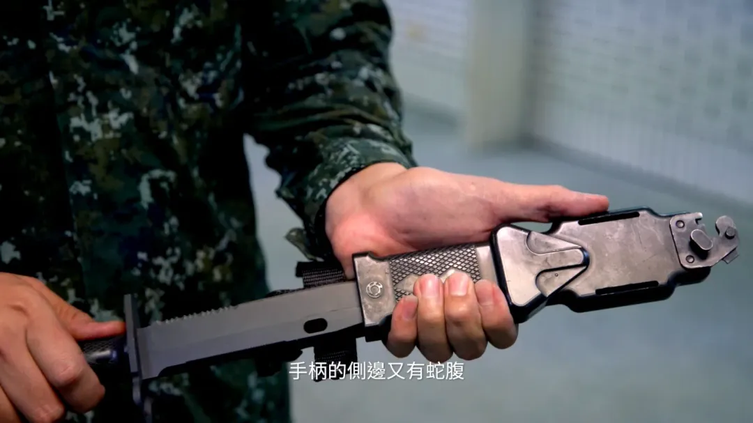 柯俊文設計新型多功能戰鬥匕首，源自排灣族圖騰，手柄上有百步蛇菱格紋，手柄側邊還有蛇腹紋路，搭配XT-112新式戰鬥步槍，有「百步穿楊」寓意。（圖取自文化總會影片）