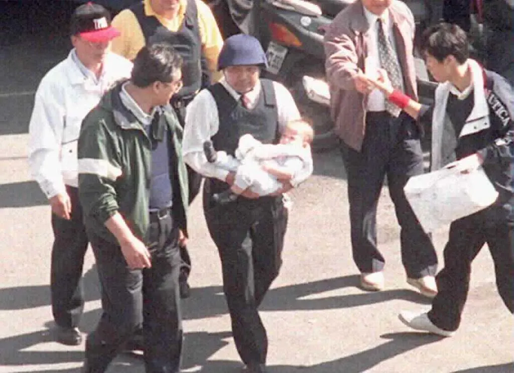 圖為侯友宜（中間白衣者）抱著南非武官幼子離開官邸的照片。（中時資料照）