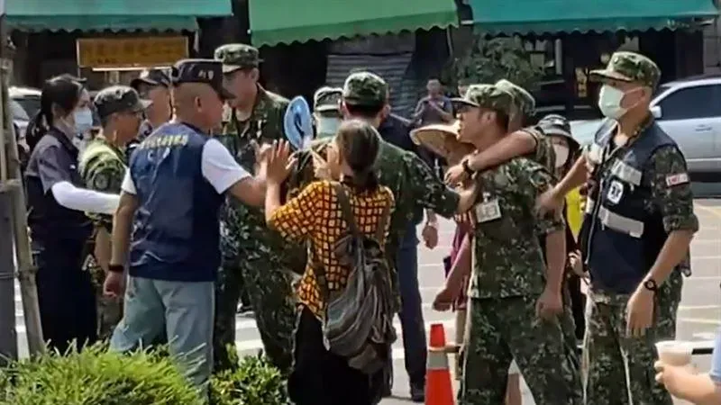 軍方人員與警員為維持排隊動向爆發激烈口角,阿姨(中)上前勸架。(圖/翻攝記者爆料網)