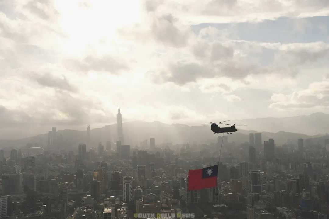 陸軍CH-47SD運輸直升機吊掛巨幅國旗,通過台北市上空。(圖/青年日報)