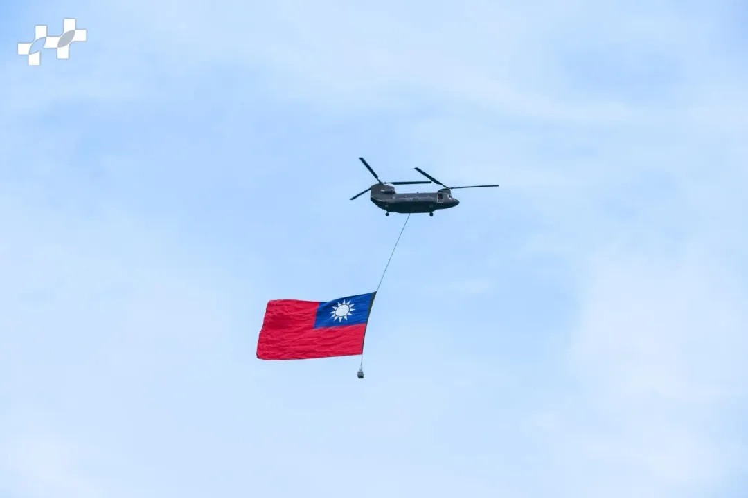 陸軍CH-47SD契努克運輸直升機吊掛巨幅國旗，通過總統府前廣場上空（圖取自中華民國讚國慶臉書）