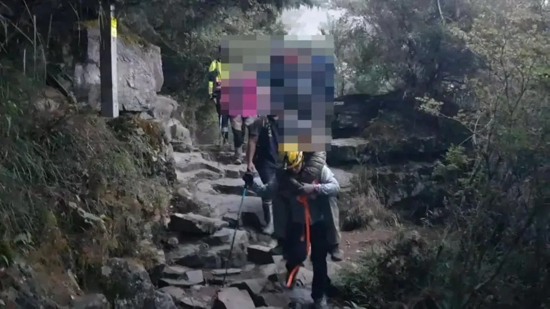 救難人員將他揹下山。（圖／警方提供）