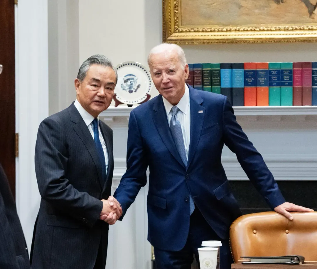 拜登與王毅握手，左手卻扶著椅子。（圖／新華社）