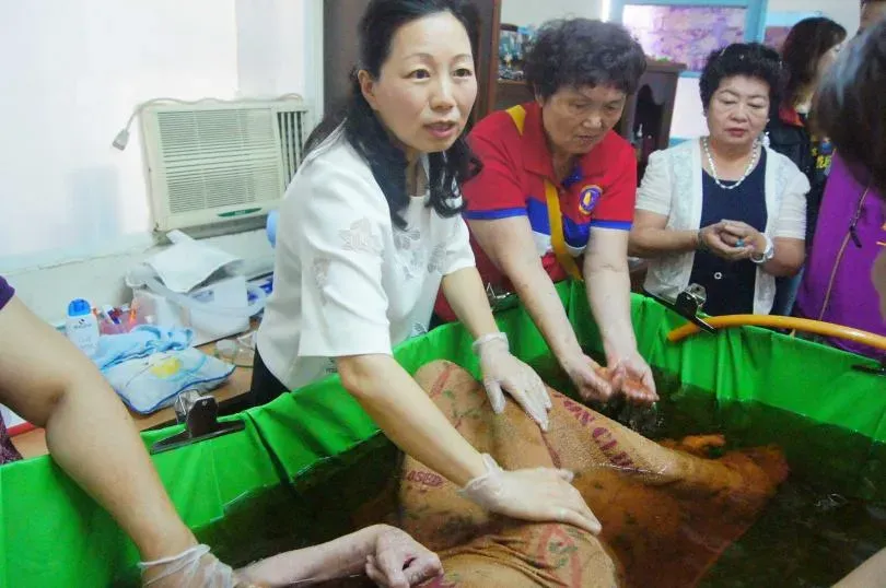 現任花蓮縣長徐榛蔚曾在2015年時，協助創世基金會志工替植物人原床泡澡，長年被擦澡的患者泡出的洗澡水呈現黑色狀態。（圖／ctwant）