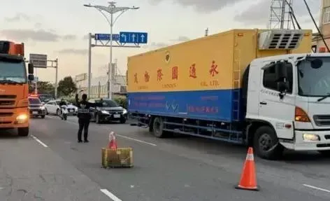 橘色大貨車違停路邊,騎士變換車道遭聯結車追撞身亡。(圖/翻攝畫面)