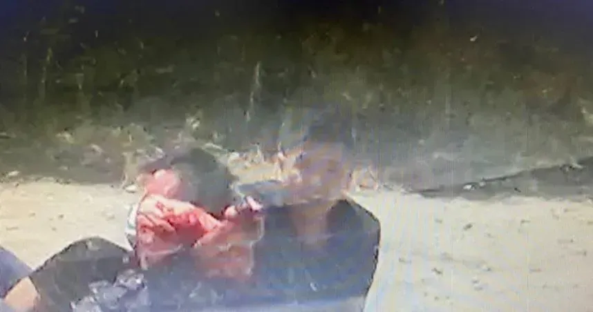 林信吾持槍挾持涂姓警員還露出詭異微笑。(圖/翻攝畫面)
