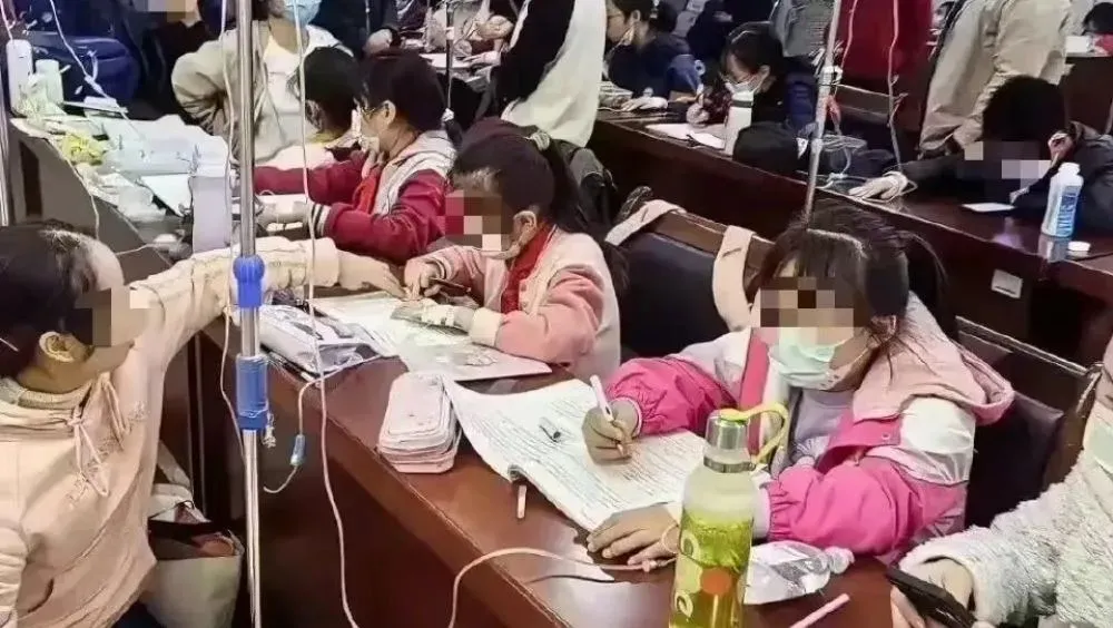 大陸呼吸道感染疾病病例激增,兒童成為主要族群。網路陸續傳出大陸學童在醫院邊吊點滴邊寫作業的畫面。(圖/翻攝微博)