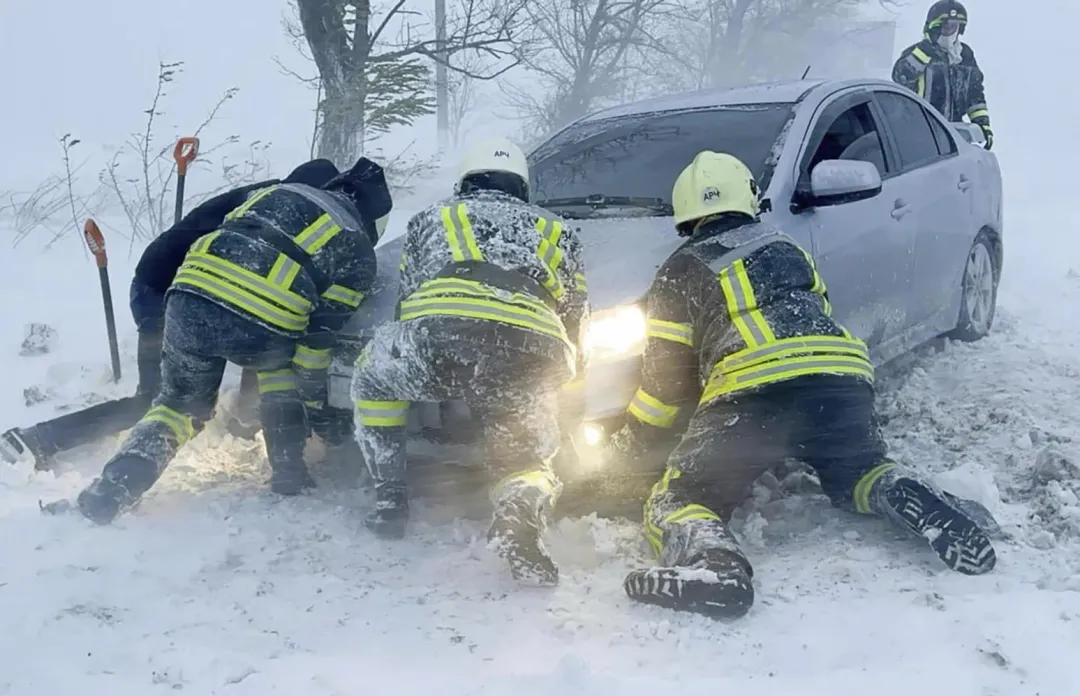 敖德薩高速公路有車輛被大雪圍困,消防出動救援。(圖/美聯社)