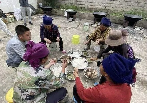 涼山有蹲地吃飯習俗,碗碟飯菜全放在地上。(圖/翻攝百度)