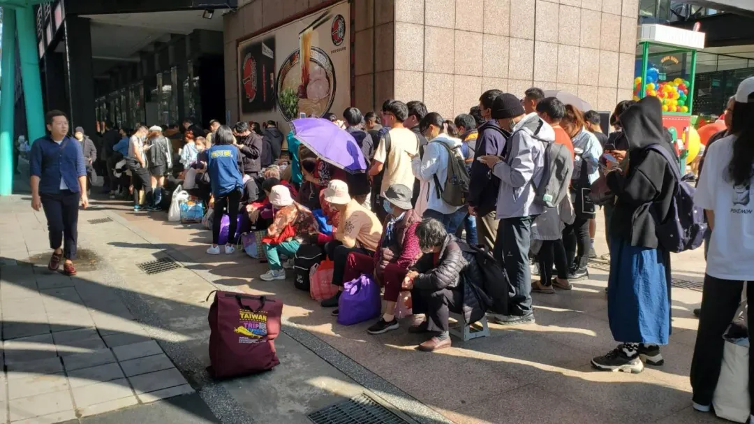 現場許多阿婆頂著豔陽,坐在板凳上排隊。(圖/程正邦攝)