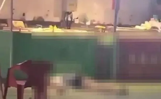 女子被高空掉落的磚頭擊中後。倒在一家賣烤串攤販前。（圖／翻攝微博）