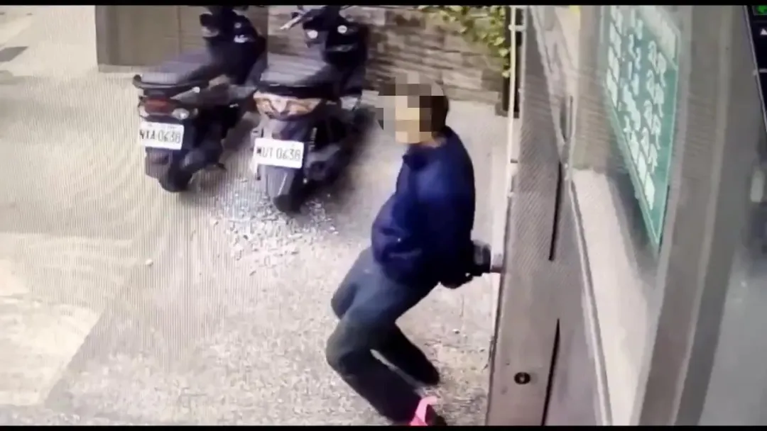 楊男背對消防出水口裝作若無其事，手卻迅速將接頭拆解偷走。（圖／翻攝畫面）