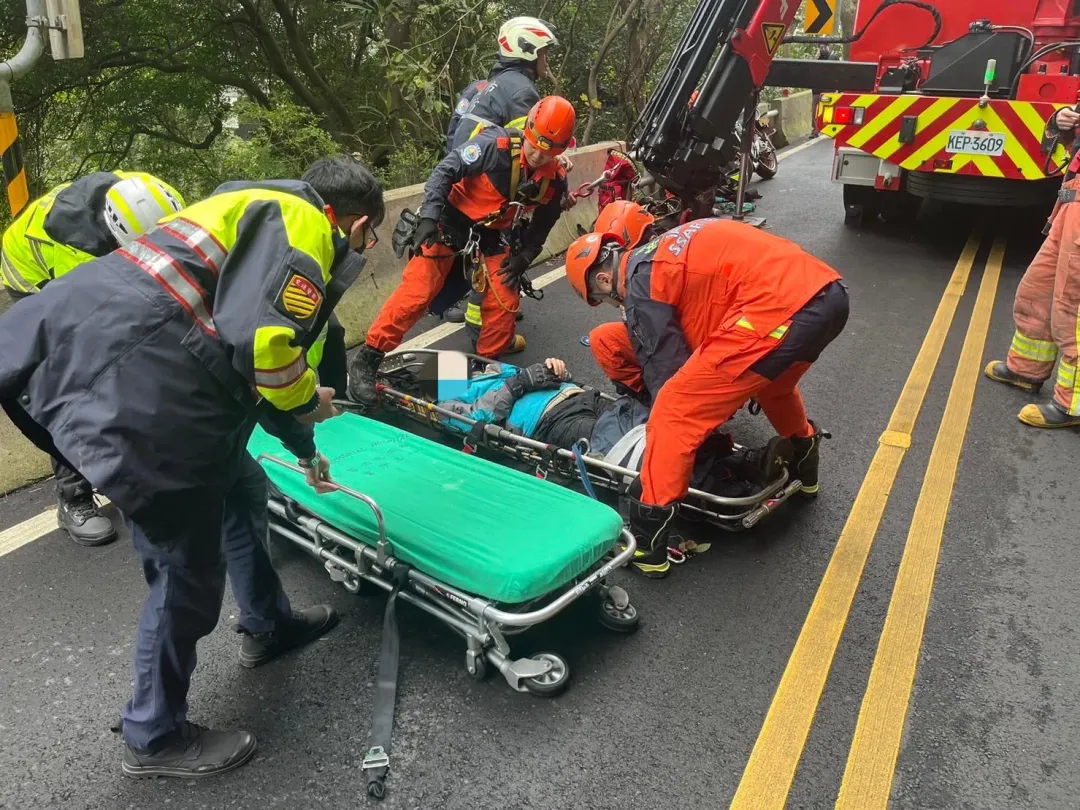 警消將傷者從邊坡救起固定在擔架上送醫治療。（圖／翻攝畫面）