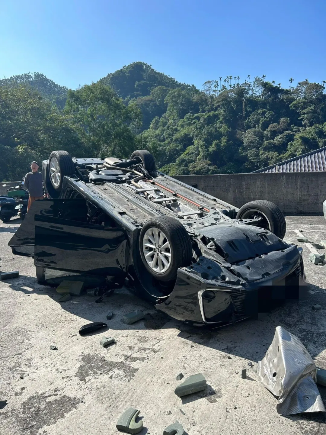 事故車輛從2樓墜落翻覆,零件噴飛散落一地。(圖/中天新聞)