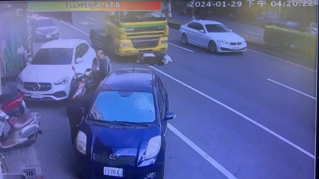 監視器拍到撞擊瞬間,騎士被撞倒地後,卡在曳引車底。(圖/中天新聞)