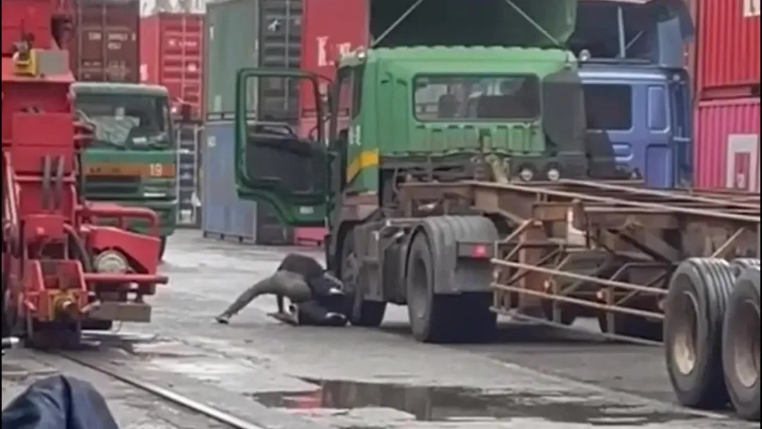 其中一名運將將對方壓制在貨車輪子前面，相當危險。（圖／翻攝記者爆料網）