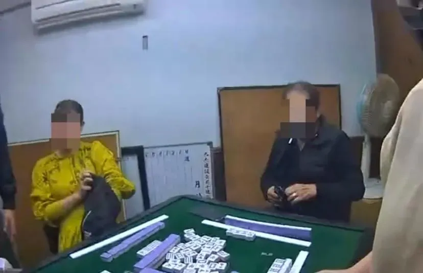 賭客在牌桌上掏出證件給警方查驗身分。(圖/翻攝畫面)