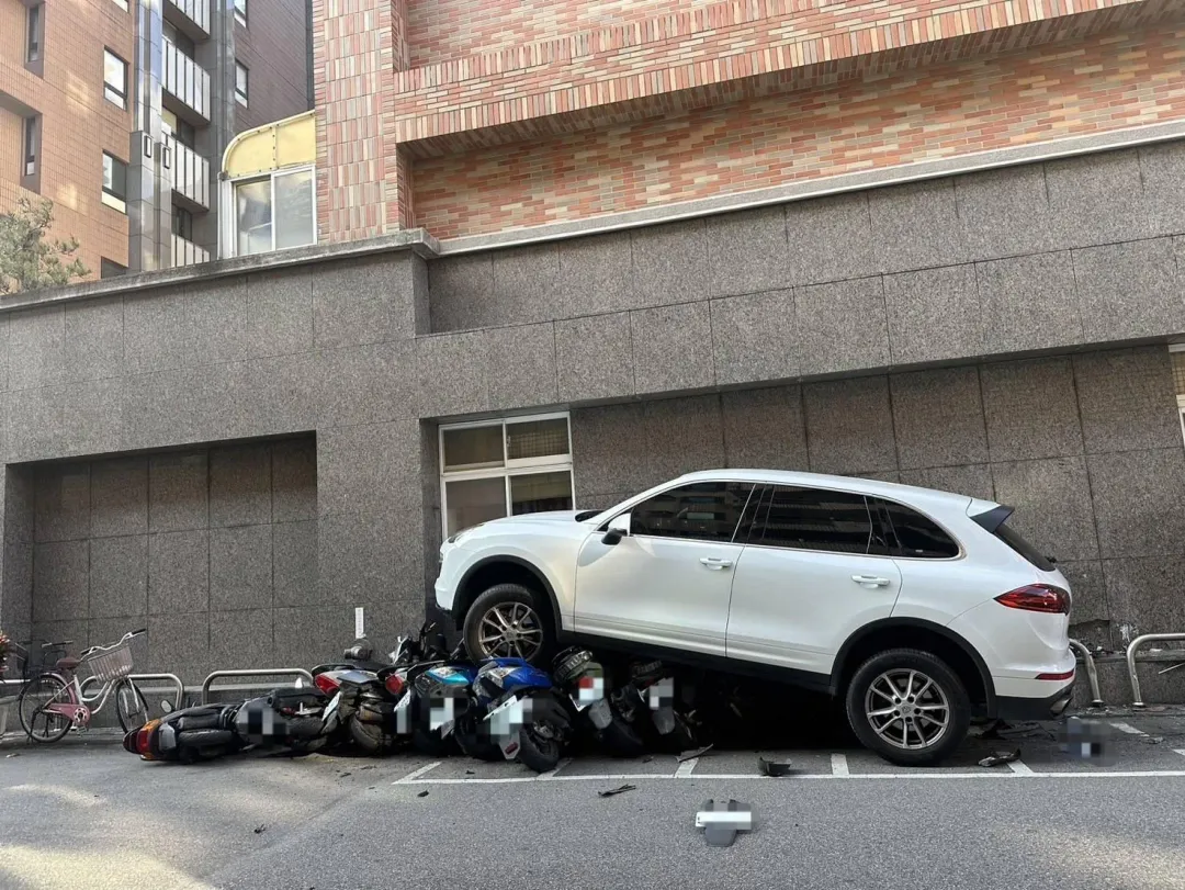 保時捷休旅車「騎上」路邊一整排機車。（圖／翻攝畫面）