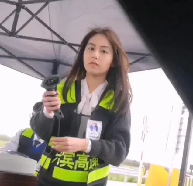 大陸廣西一處人工收費站通道出現一位長髮飄逸的美麗收費員,吸引許多過路駕駛目光。(圖/翻攝自微博)