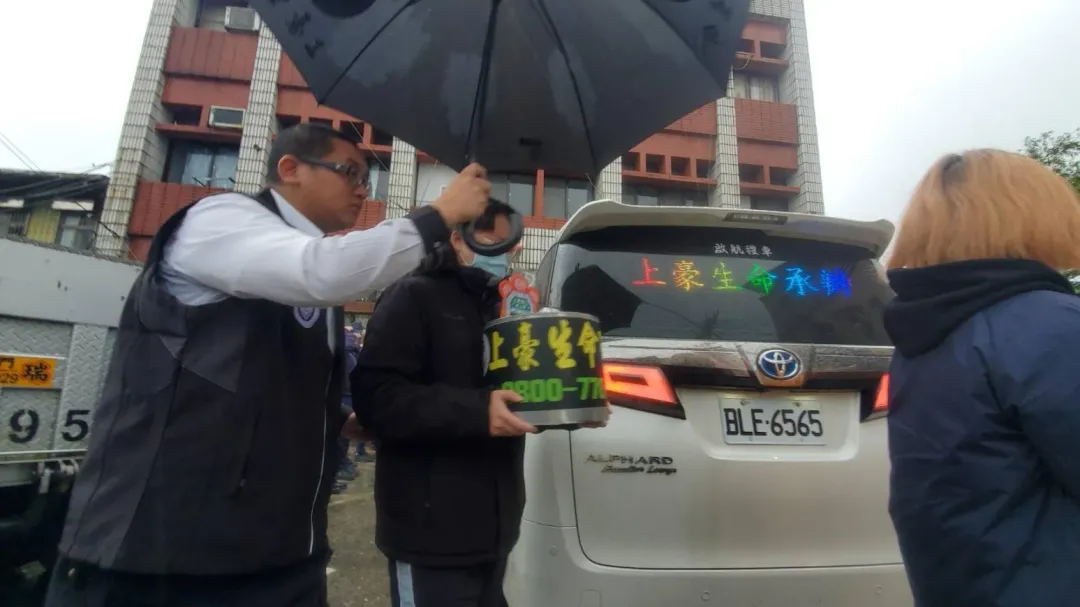 蘇姓員警的妹妹(左2)捧著哥哥牌位,將遺體送往板橋殯儀館。(圖/記者程正邦攝影)