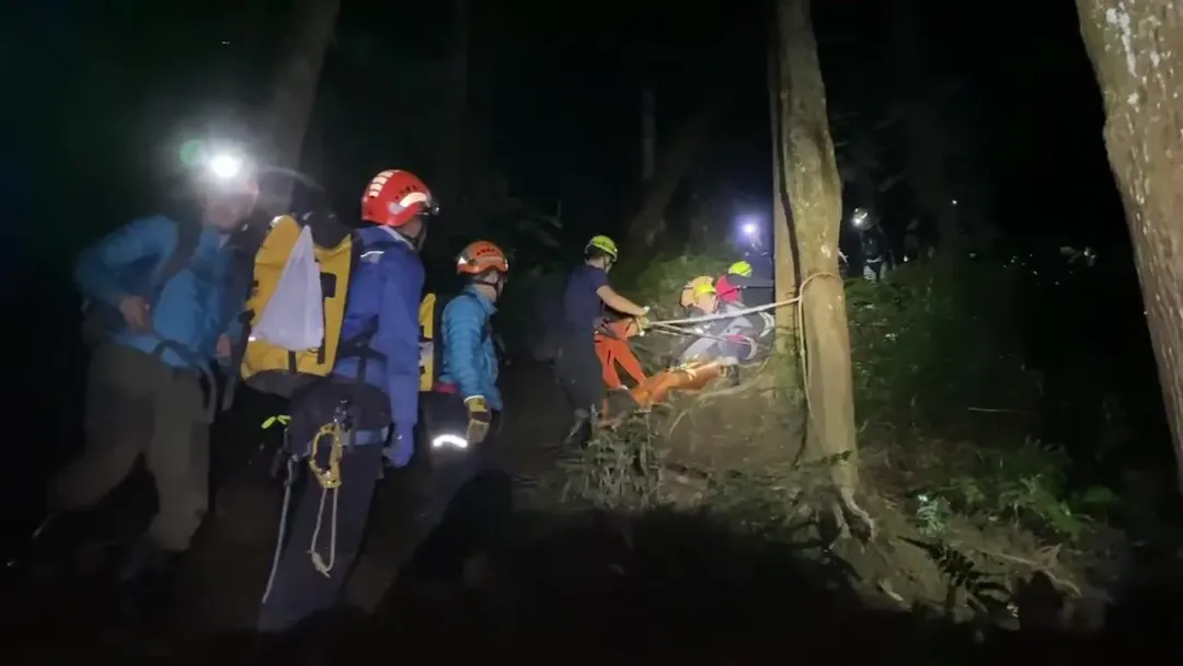 山谷地形陡峭，16名消防員花了5個小時，才將大體搬運到登山口。（圖／翻攝畫面）