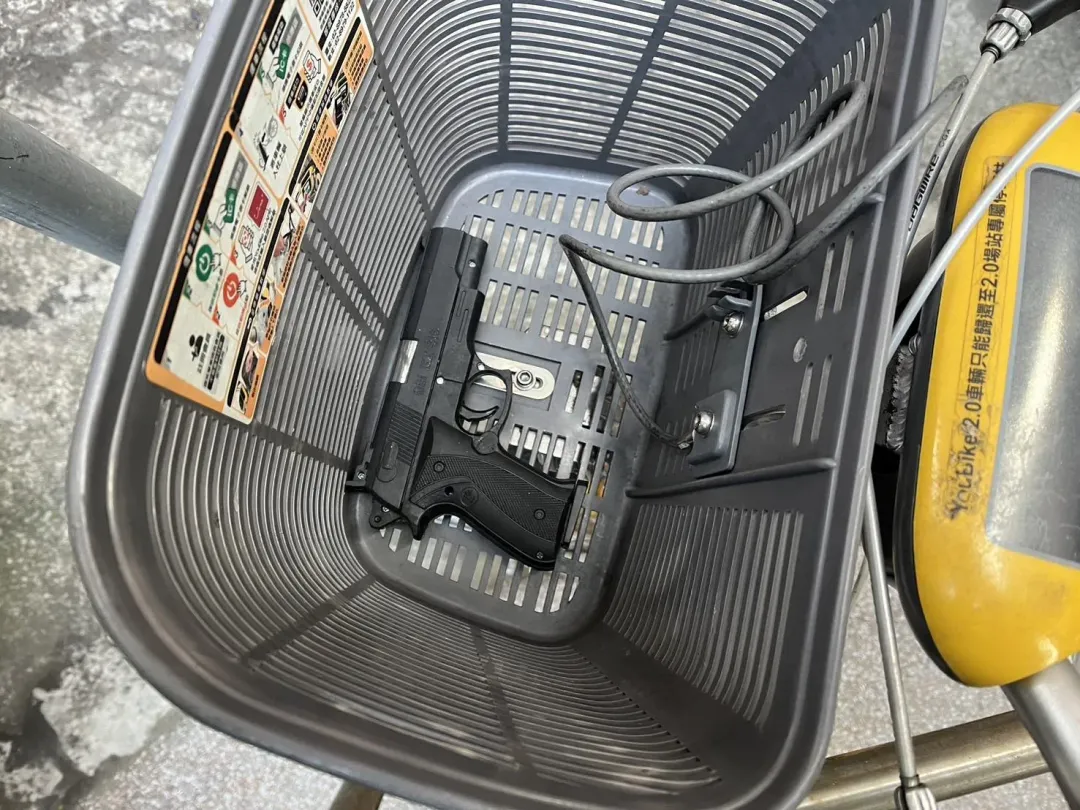 單車菜籃內放著一把黑色手槍。(圖/翻攝畫面)