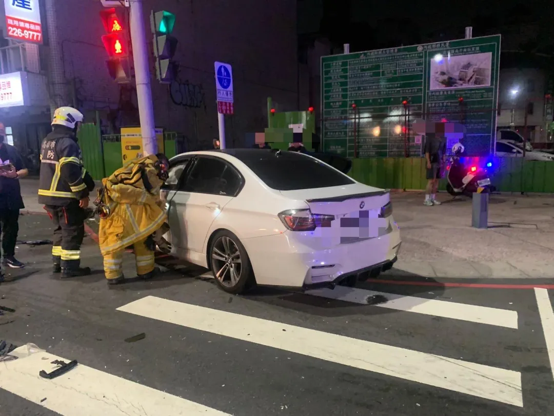 白色BMW被撞後失控撞上路邊燈桿,駕駛受困車上。(圖/翻攝畫面)