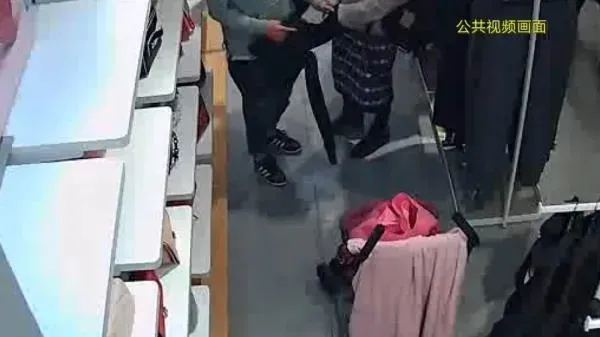 兩人將偷竊到的衣服塞進自己隨身所帶的包裡。（圖／翻攝微博）