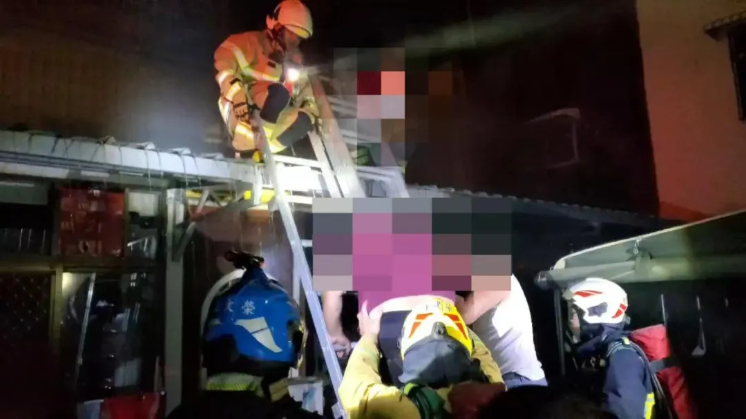 消防員用梯子爬上二樓,從冷氣窗口救出受困父子。(圖/翻攝畫面)
