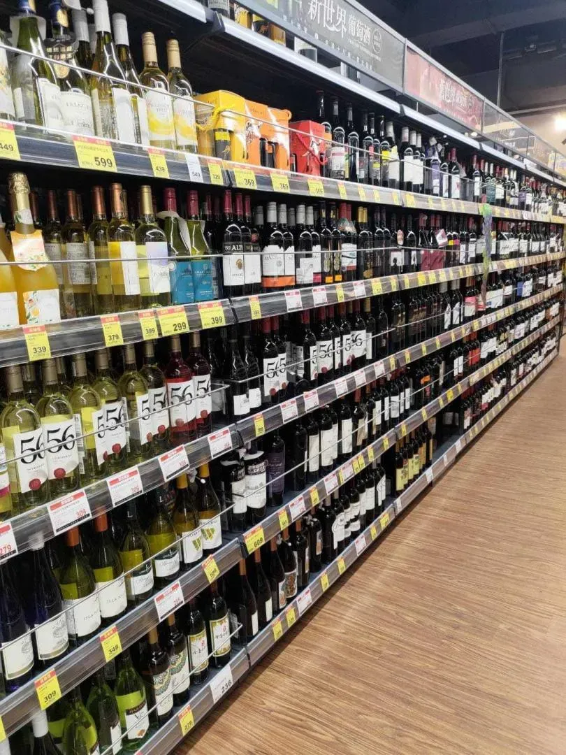 有量販店用透明隔板把1排排的酒瓶固定在架上。（圖／翻攝自臉書／路上觀察學院）