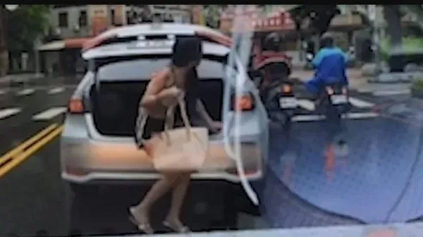 高雄一輛汽車停等紅燈過程,後車箱突然爬出一名短褲女子讓網友看傻。(圖/翻攝網路)
