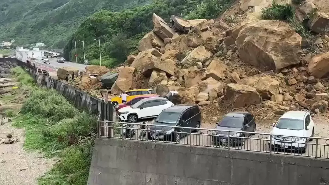 基隆市中正區潮境公園3日下午2時許驚傳土石山崩,大量土石掉落,瞬間掩蓋馬路,阻斷交通,導致2名中年男子輕傷。(圖/翻攝畫面)