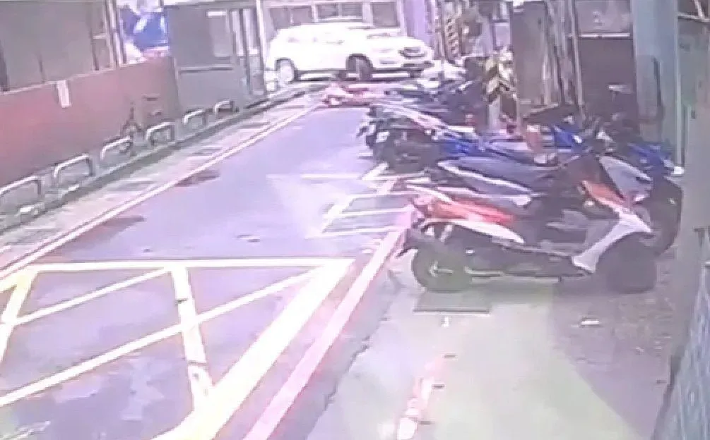 監視器拍下勵男駕駛休旅車輾過張女的過程。（圖／翻攝畫面）