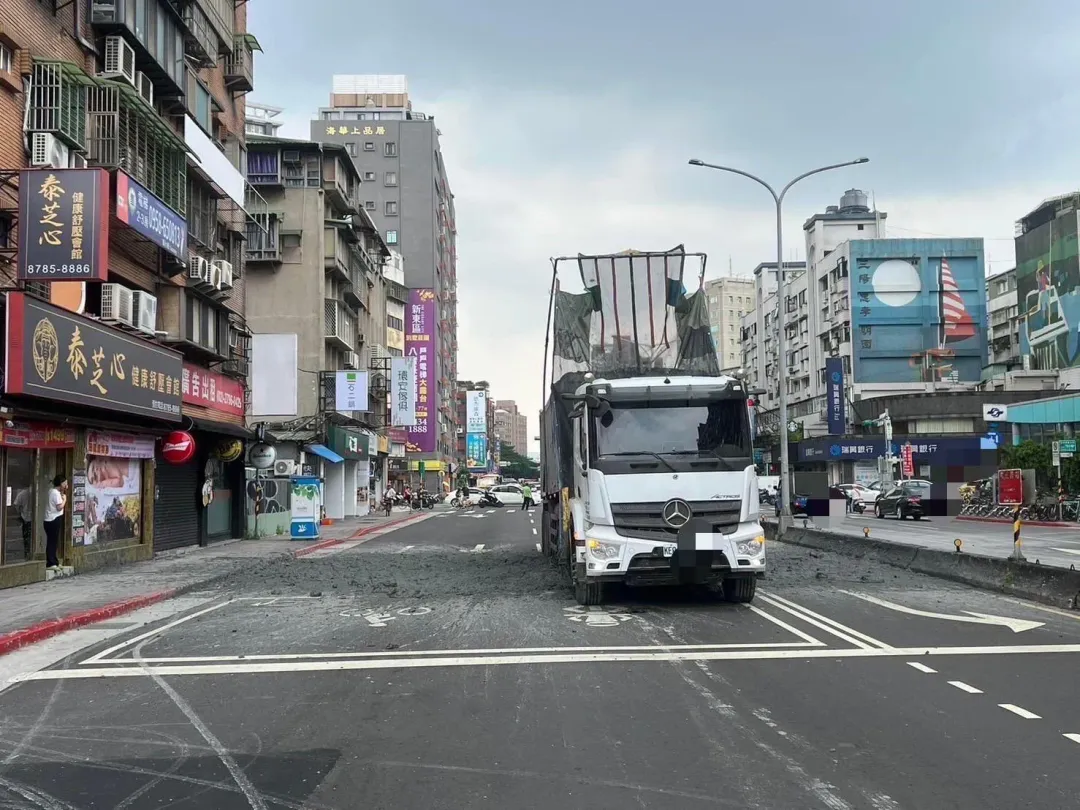 曳引車駕駛於今(19)日上午11時16分,行經忠孝東路五段時,車上裝載的泥漿滲漏路面阻礙車輛通行。(圖/民眾提供)