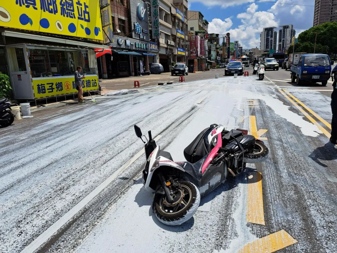 車上所載5桶白色水泥漆掉落地面,導致後方行經4部機車打滑摔傷送醫。(圖/民眾提供)