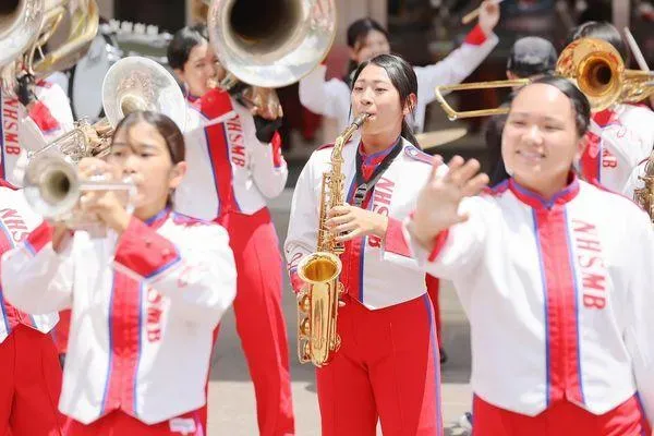 學生頻頻向觀眾揮手致意，民眾直呼「卡哇伊」。（圖／攝自中華文化總會）
