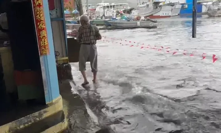 旗津地區輪渡站一帶上午發生海水倒灌,造成鄰近地區及地勢低漥的公有市場一帶淹水至腳踝,甚至水進住家中。(圖/翻攝畫面)