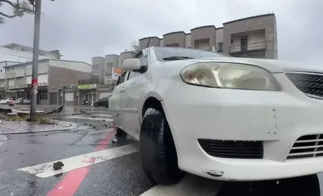 花蓮縣花蓮市一棟民宅昨因凱米颱風帶來的強風導致女兒牆倒塌,砸中路上一輛白色小客車,車上母子一死一重傷。(圖/翻攝畫面)