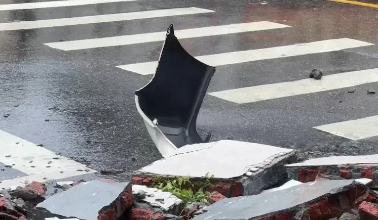 花蓮縣花蓮市一棟民宅昨因凱米颱風帶來的強風導致女兒牆倒塌,砸中路上一輛白色小客車,車上母子一死一重傷。(圖/翻攝畫面)