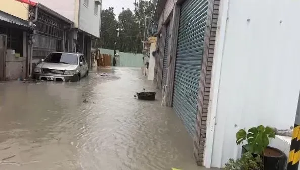 屏東市長安里河濱公園旁道路水淹近半台車高度，整條馬路汪洋一片。（圖／翻攝畫面）