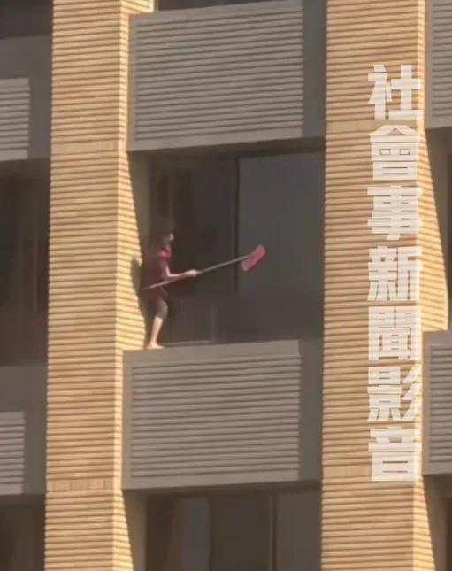 婦人單腳危險站在窗外擦玻璃。(圖/翻攝自社會事影音)