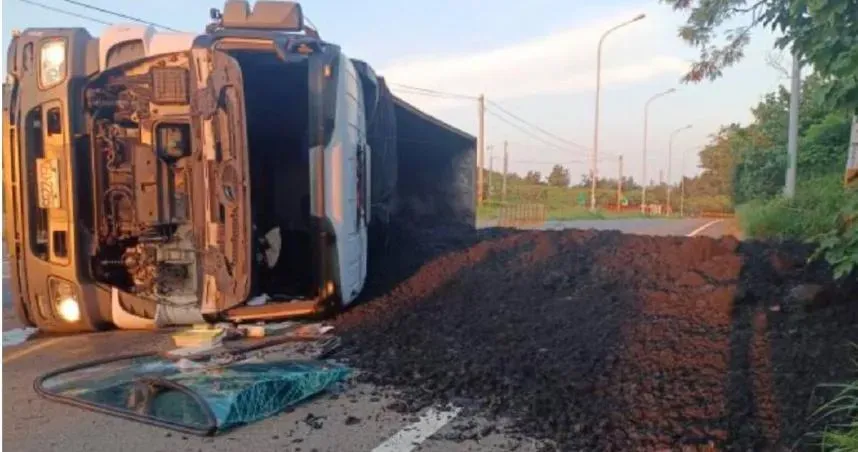 台61線後龍交流道有1輛曳引車突爆胎側翻,導致車上裝載的廢土撒落車道。(圖/翻攝畫面)