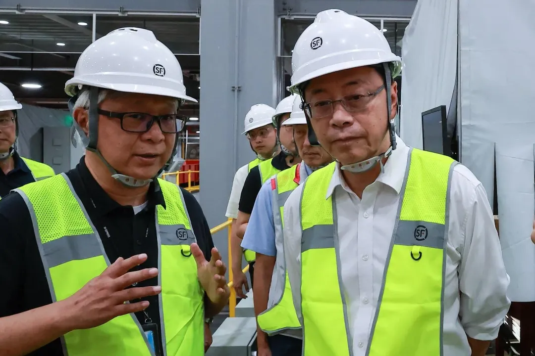 台灣順豐總經理潘逸俊向桃園市長張善政說明全自動化分揀設備運作模式，大幅提升貨件轉運效率。（圖／台灣順豐提供）
