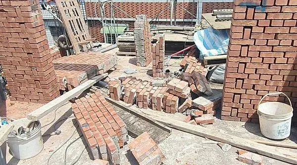 桃園市八德區某處興建中工地圍牆今天上午9時許突然倒塌,余姓工人受困。(圖/桃園市大湳消防分隊提供)