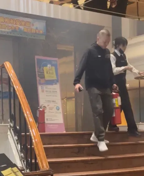 錢櫃板橋店內電梯發生火警，員工拿著滅火器撲滅火勢。（圖／網友chen_8417授權提供）
