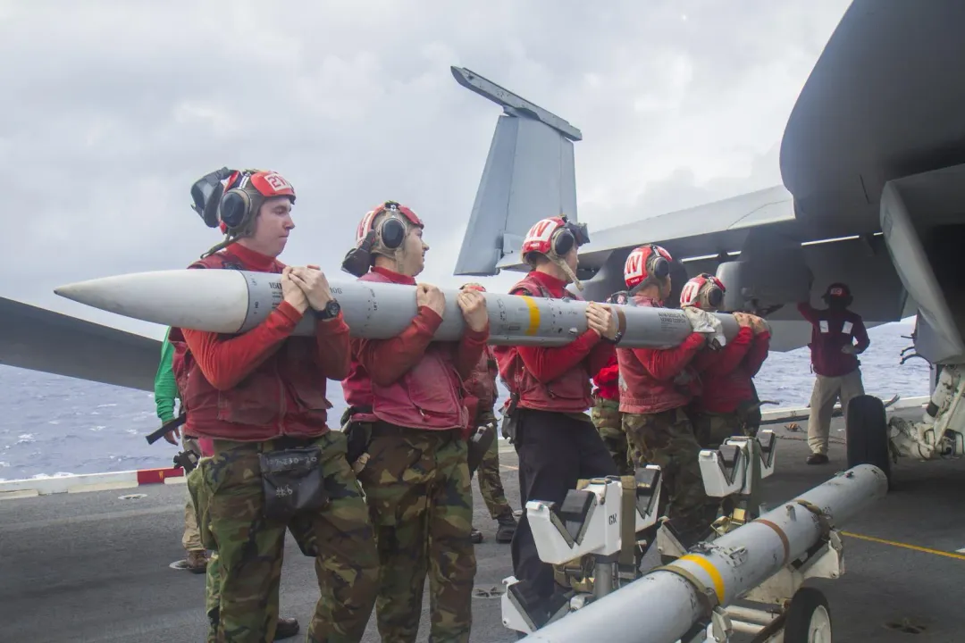 美軍在航艦上準備裝掛AIM-120飛彈。(圖/美國海軍)