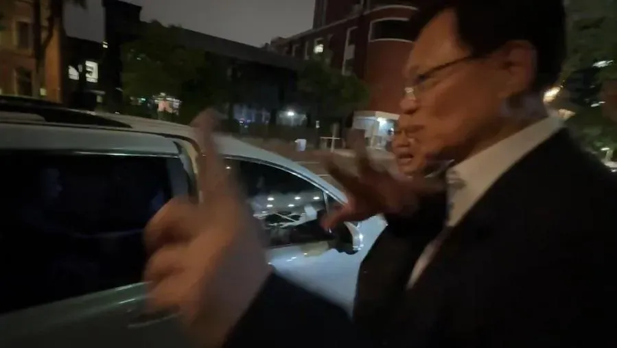 立委張啟楷和林國成護送柯文哲上車離開,並表示明天會把所有問題一次講清楚。(圖/中天新聞)
