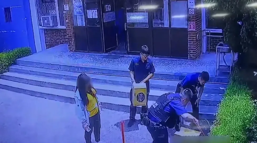 警方協助將眼鏡蛇壓制困住，以防止蛇跑出傷人。（圖／警方提供）