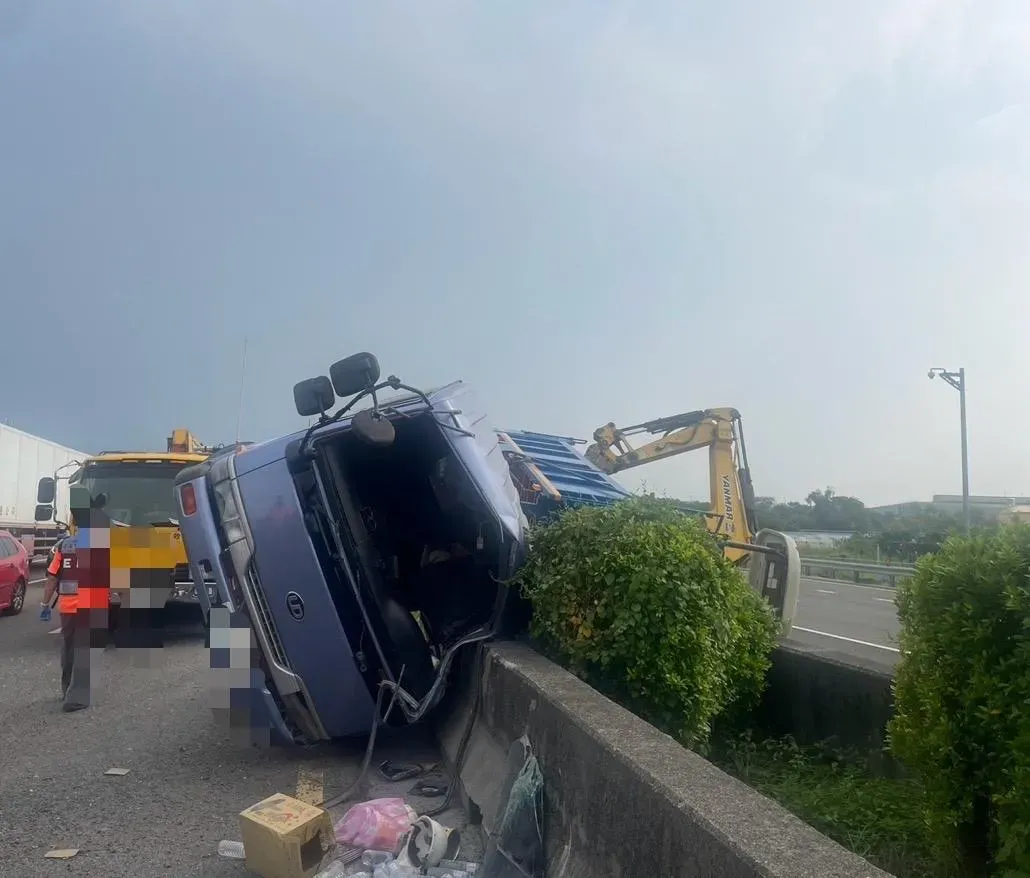 大貨車失控撞擊內側護欄，側翻於中央分隔島。（圖／翻攝畫面）